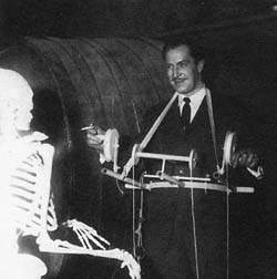 Price, cigarrillo en mano, con los surrealistas mandos de su esqueleto